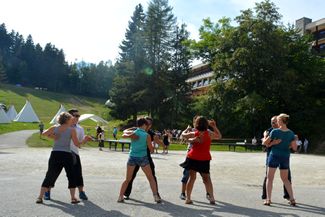 stage danse sur la place du village, dans le fond le club hôtel et les tipis ; le village club des 300 stages, vacances à Valmorel dans les Alpes de Savoie. La danse en vacances à la montagne ! 