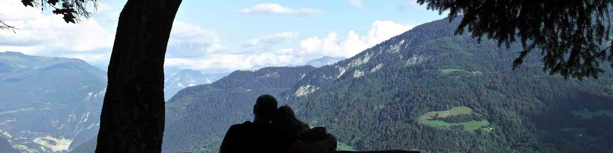 Couple sur un banc devant un paysage de montagne